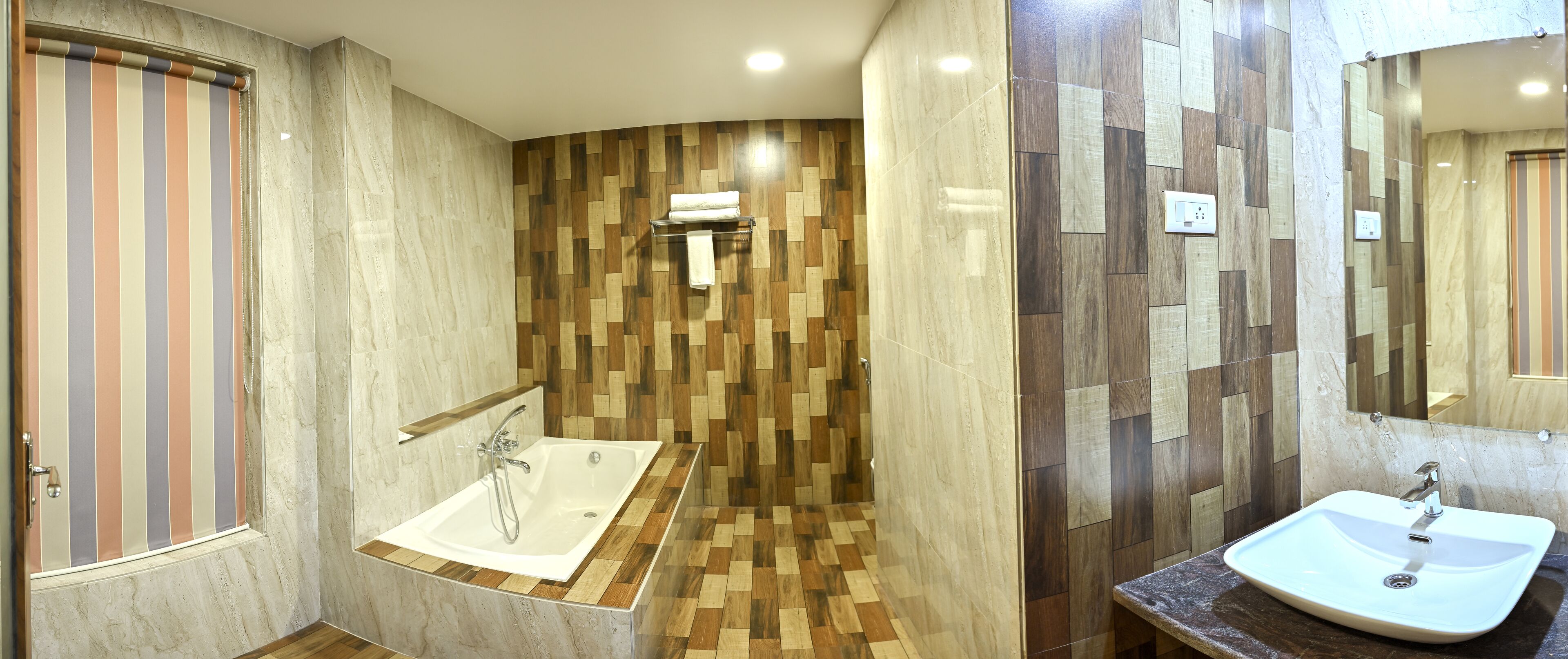 A modern bathroom with a wooden-patterned wall, a bathtub, a sink, and a shower.