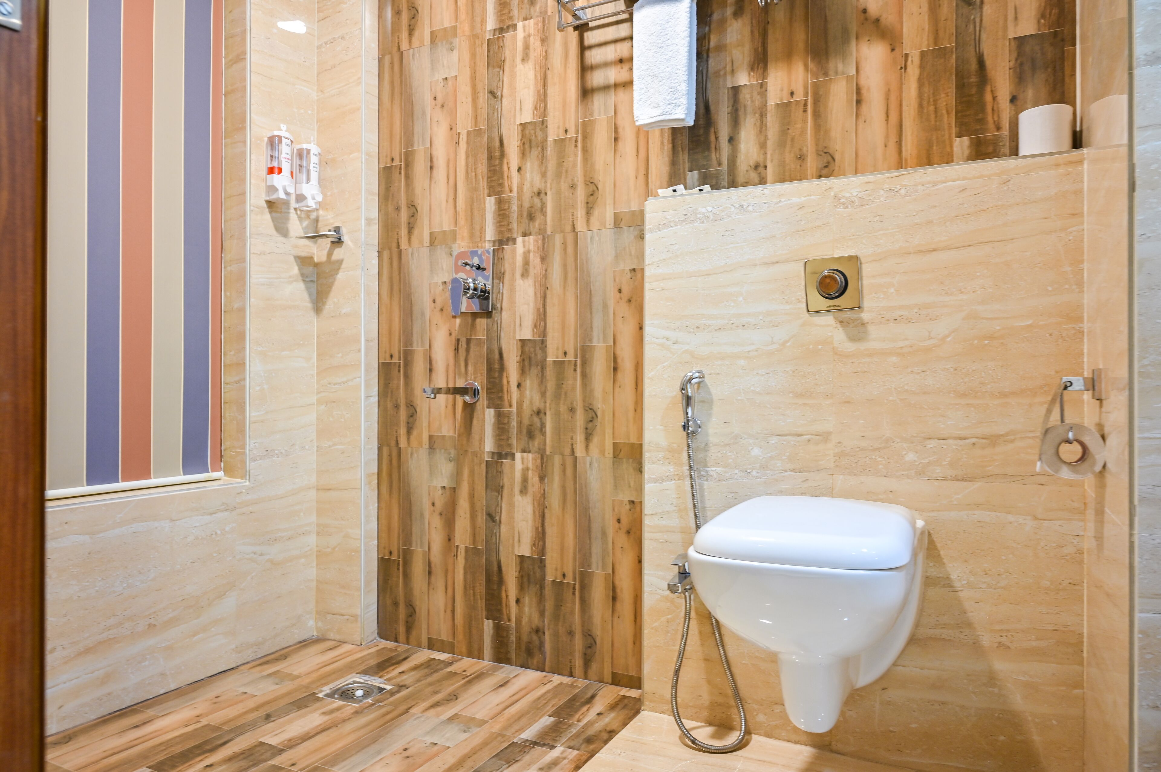 Uma casa de banho moderna com design em parede de madeira, sanita branca e zona de duche.