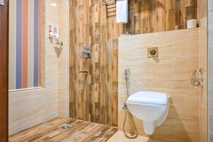 Uma casa de banho moderna com design em parede de madeira, sanita branca e zona de duche.