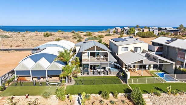 A coastal residential area with modern houses, a swimming pool, and a view of the sea. - 108 Madaffari Drive - bring your boat! (EXMOUTH)