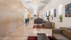 En modern hotellobby med en lång korridor, en sittgrupp och konstverk på väggarna.