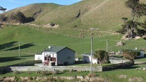 Un petit bâtiment d’un seul étage, doté d’un toit plat, d’un patio couvert et d’une cour clôturée.