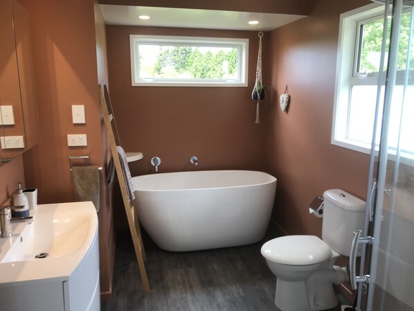 A bathroom with a freestanding bathtub, a toilet, and a sink.