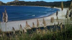 A coastal landscape with a beach, clear blue water, and distant hills. - Barrier Headquarters entire complex. Unobstructed 270 degree view beach/mountain (Medlands Beach)