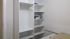 A white closet with multiple shelves and hanging space. - 211, 2-bedroom apartment near the beach (Bombas)