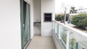 A balcony with a glass door, a small sink, and a window. - 211, 2-bedroom apartment near the beach (Bombas)