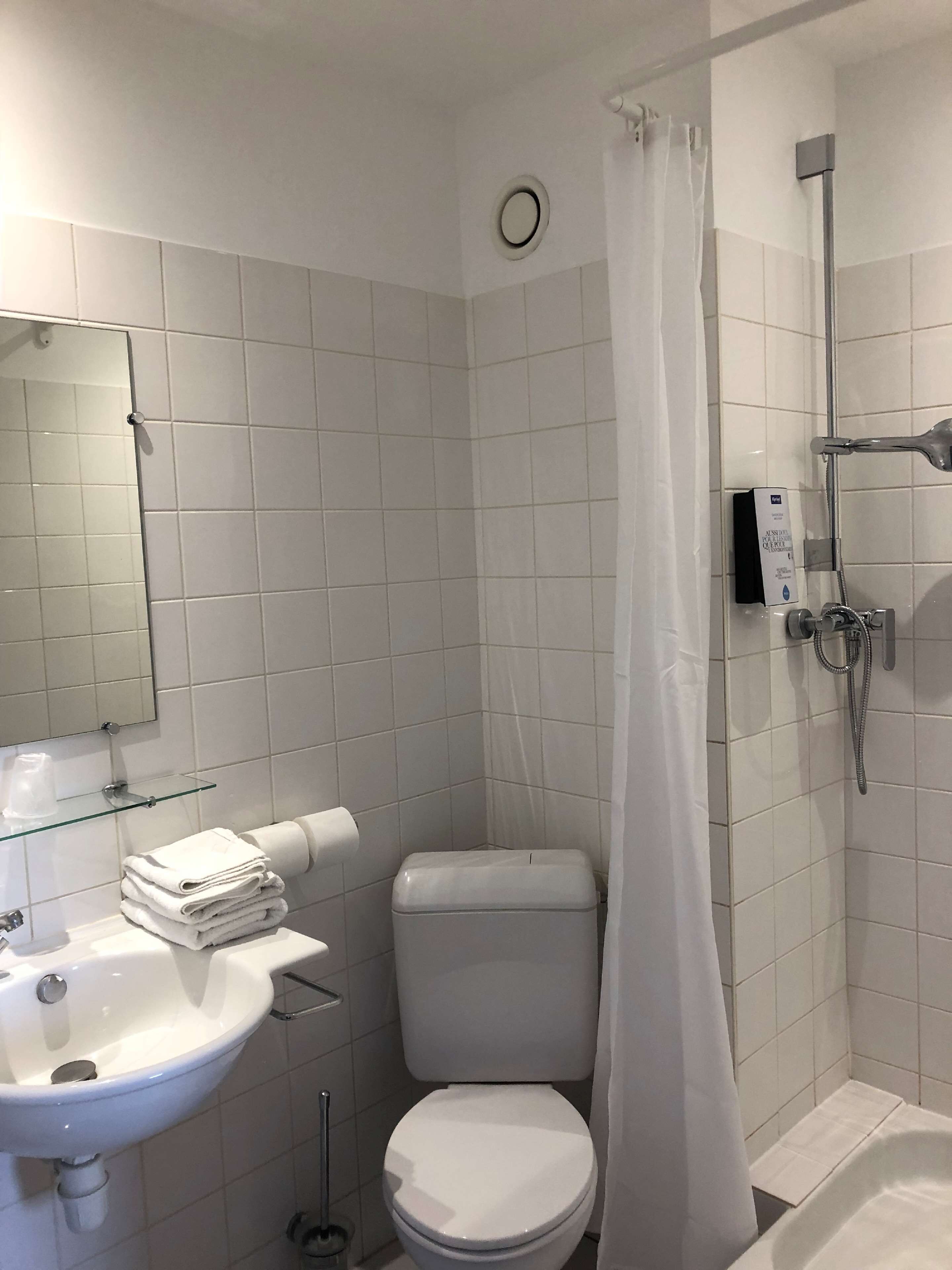 A bathroom with a toilet, sink, and shower.