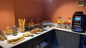 A breakfast buffet with various food items and a coffee machine.