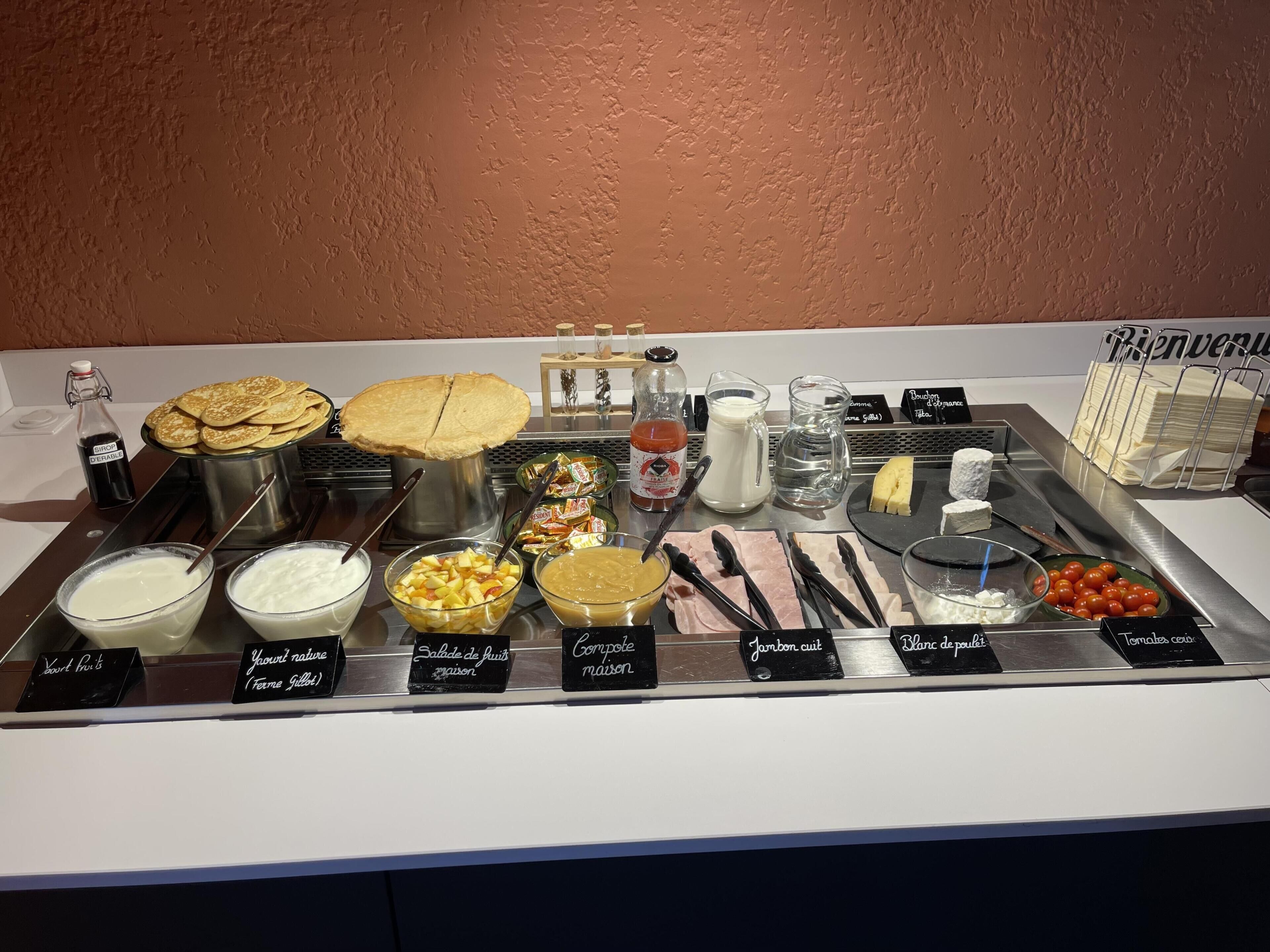 Una mesa de buffet con diversos alimentos y salsas.