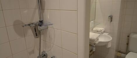 Un baño con ducha, lavabo e inodoro.