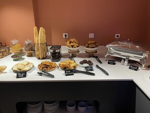 Un bufé con diversas opciones de comida y un tostador.
