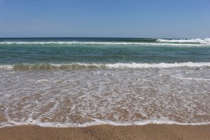 Una playa con olas acercándose a la orilla.
