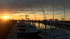 A marina with boats docked at the pier during sunset. - SPACIOUS & PRIVATE 6 BEDRM HOME CLOSE TO THE OCEAN & BIKE PATH! (Eastham)