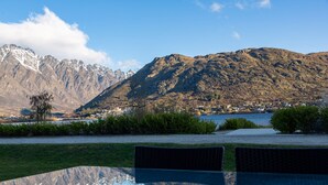 A clear view of a mountain range with a lake and a town in the background. - Marina 2 Bdrm Apartment with Views (Frankton)
