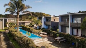 Ein modernes Hotel mit Pool, Außenbereich und Blick auf Hügel.