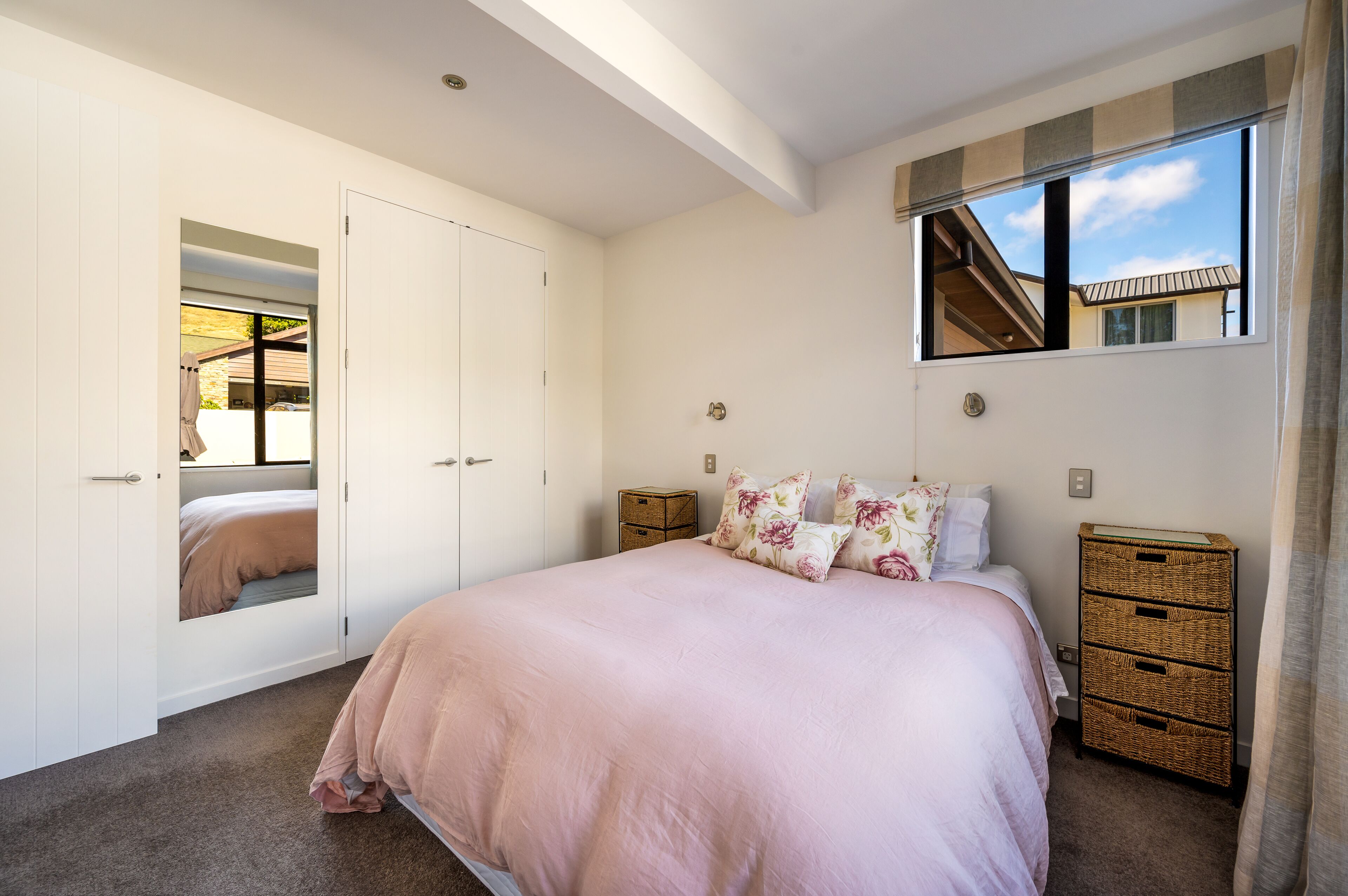 Una camera da letto con un letto grande, un armadio, un comò e una finestra vista edificio.