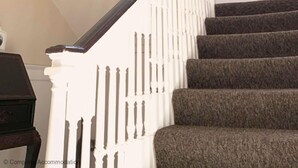 A staircase with white railings and carpeted steps.