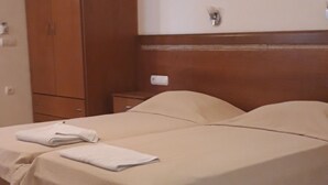 A bedroom with a bed, a wardrobe, and a nightstand. - Dabasis-Drolias (Skiathos)