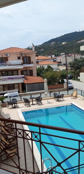 A rooftop pool area with a clear view of the surrounding buildings and hills. - Dabasis-Drolias (Skiathos)