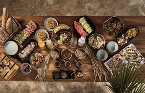 A wooden table with various food items and condiments. - Anemelia Retreat (Zakynthos)