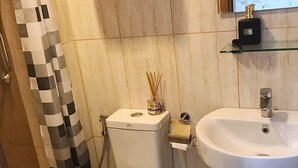 Une salle de bain avec des toilettes, un lavabo et un rideau de douche.
