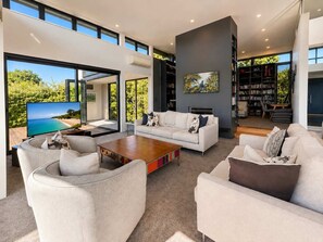 A modern living room with a large flat-screen TV, a fireplace, and a bookshelf.