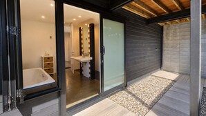 A modern bathroom with a bathtub, a sink, and a mirror.