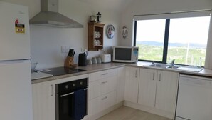 Una cocina moderna con armarios blancos, una estufa, un microondas y un fregadero.