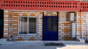 A building with a blue door and a sign reading "Baykal Motel - Pansiyon." - Baykal Pansiyon (Finike)
