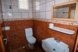 Un baño con inodoro, lavabo y espejo.