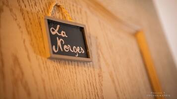 Une enseigne portant l’inscription « La Ronce » est fixée à un mur en bois.