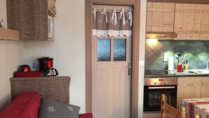 Un salon confortable avec un canapé, une machine à café et un meuble en bois.