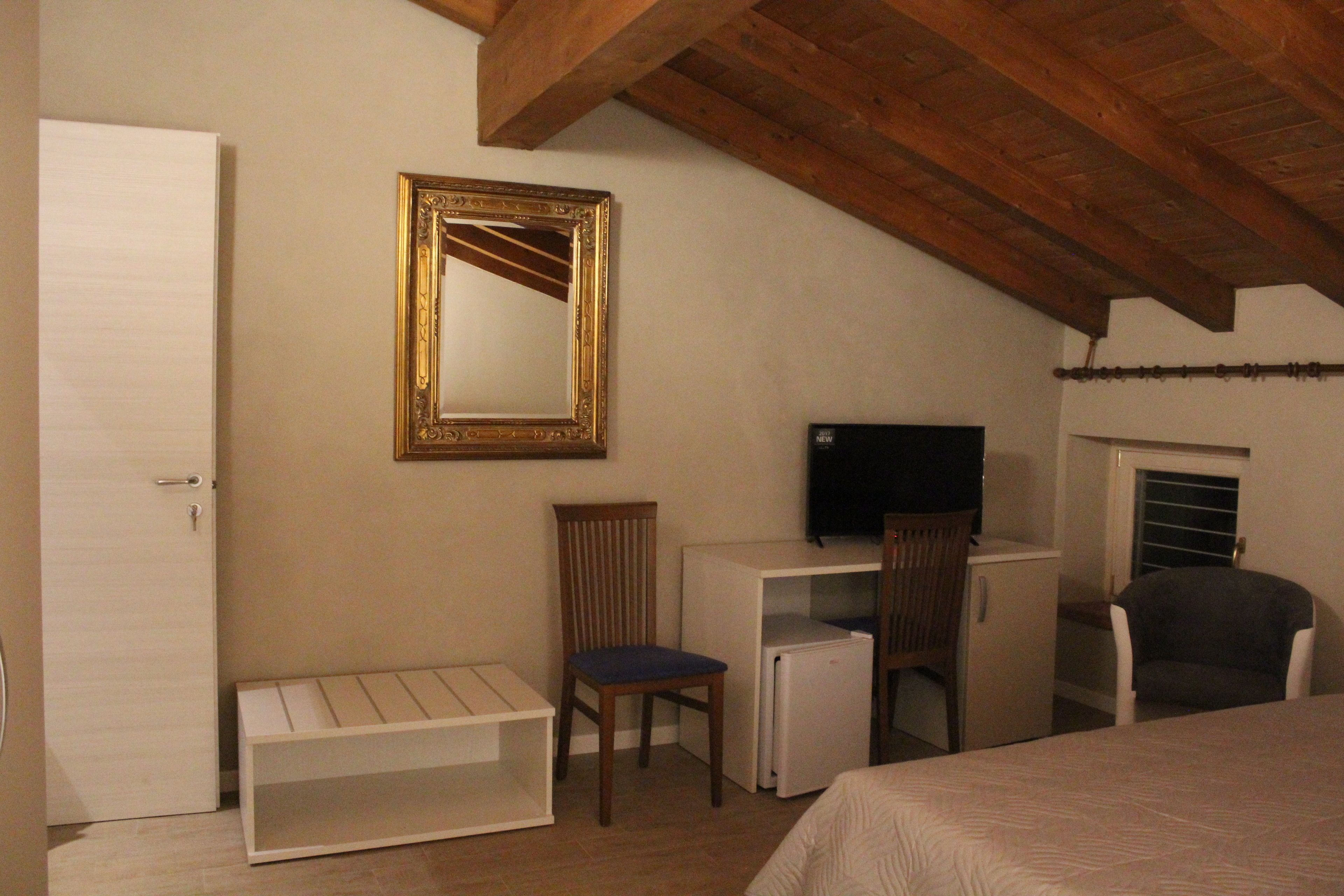 Un dormitorio con cama, escritorio, silla, televisor y armario.