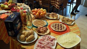A table with various food items including bread, eggs, cheese, and fruits. - B&B Eldorado (Sommacampagna)