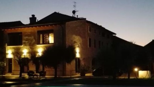 A swimming pool with a building in the background. - B&B Eldorado (Sommacampagna)