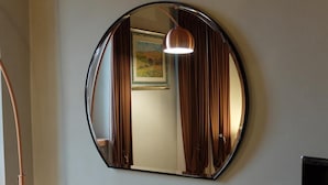 A round mirror with a copper frame on a wall. - B&B Eldorado (Sommacampagna)