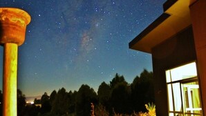 A night sky with stars visible through a building's window. - The Paris Suite cottage - gorgeous views on 7 acres Mapua seaside village Nelson (Upper Moutere)
