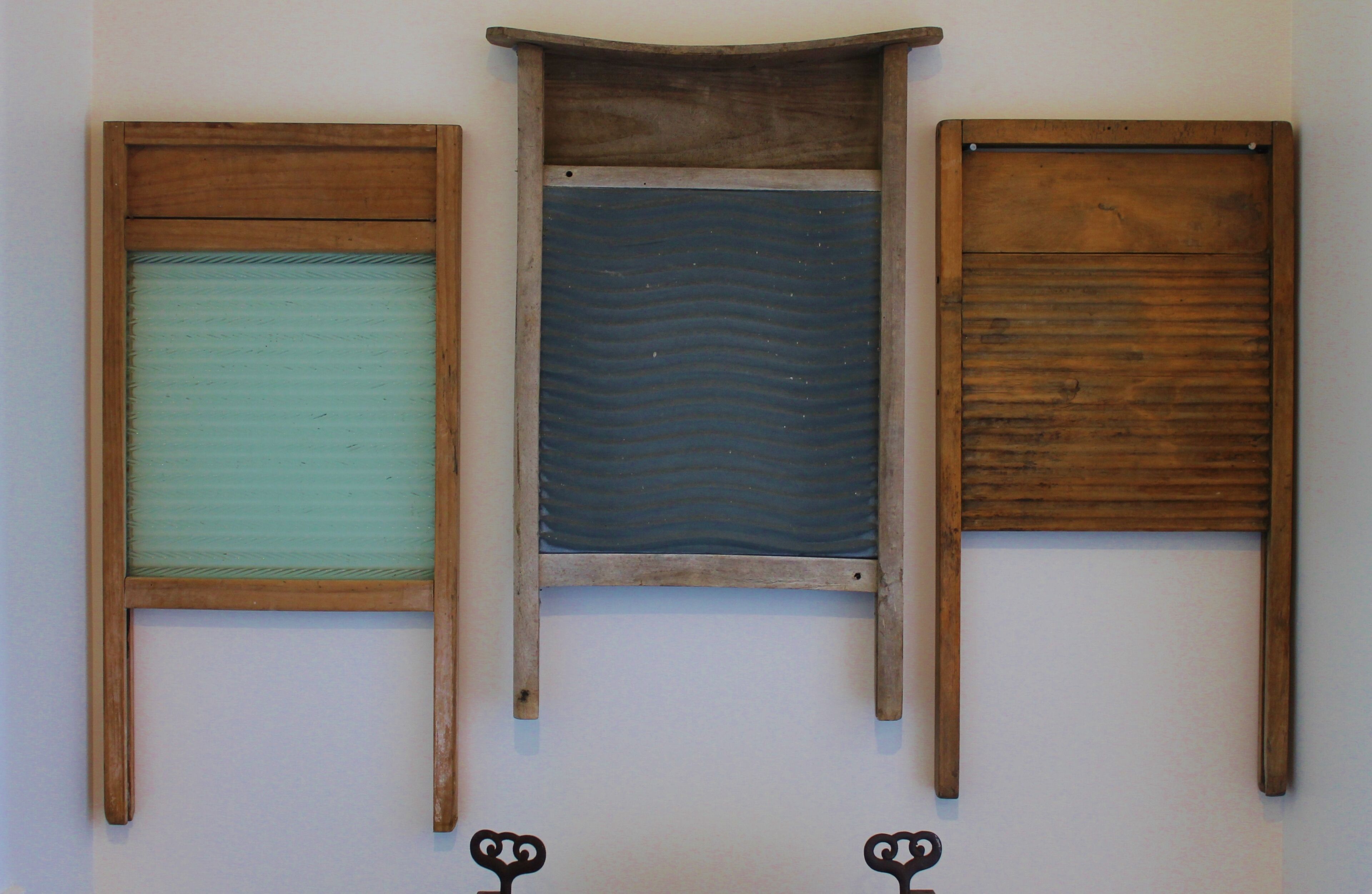 Three wooden panels with different textures and colors, mounted on a wall.