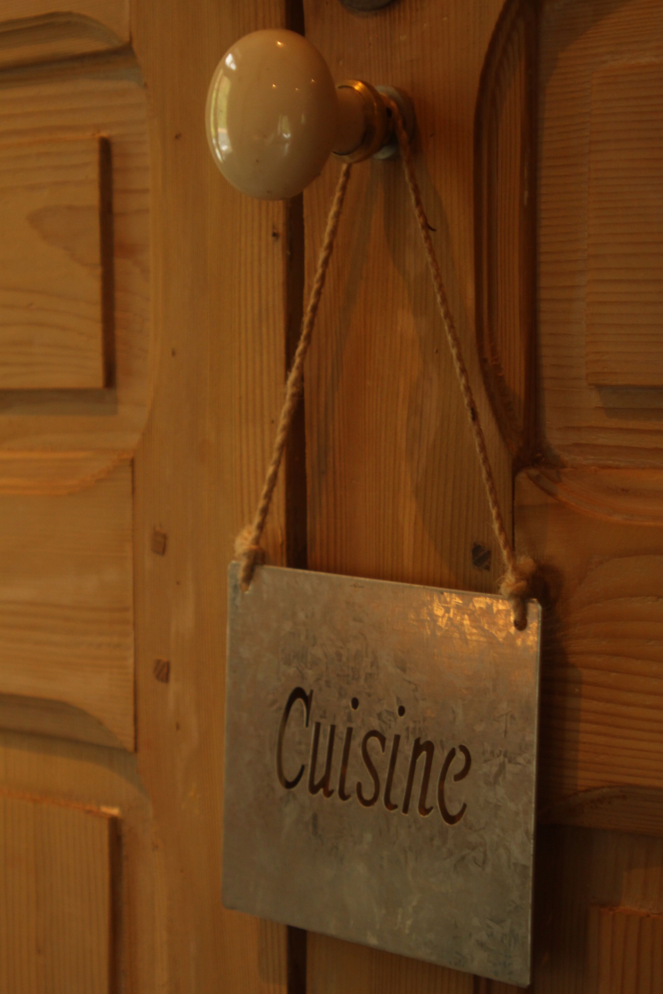 Una puerta de madera con un letrero que dice 'Cuisine'.