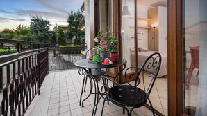 Ein Balkon mit Tisch und Stühlen, einer Topfpflanze und Blick auf die Umgebung.