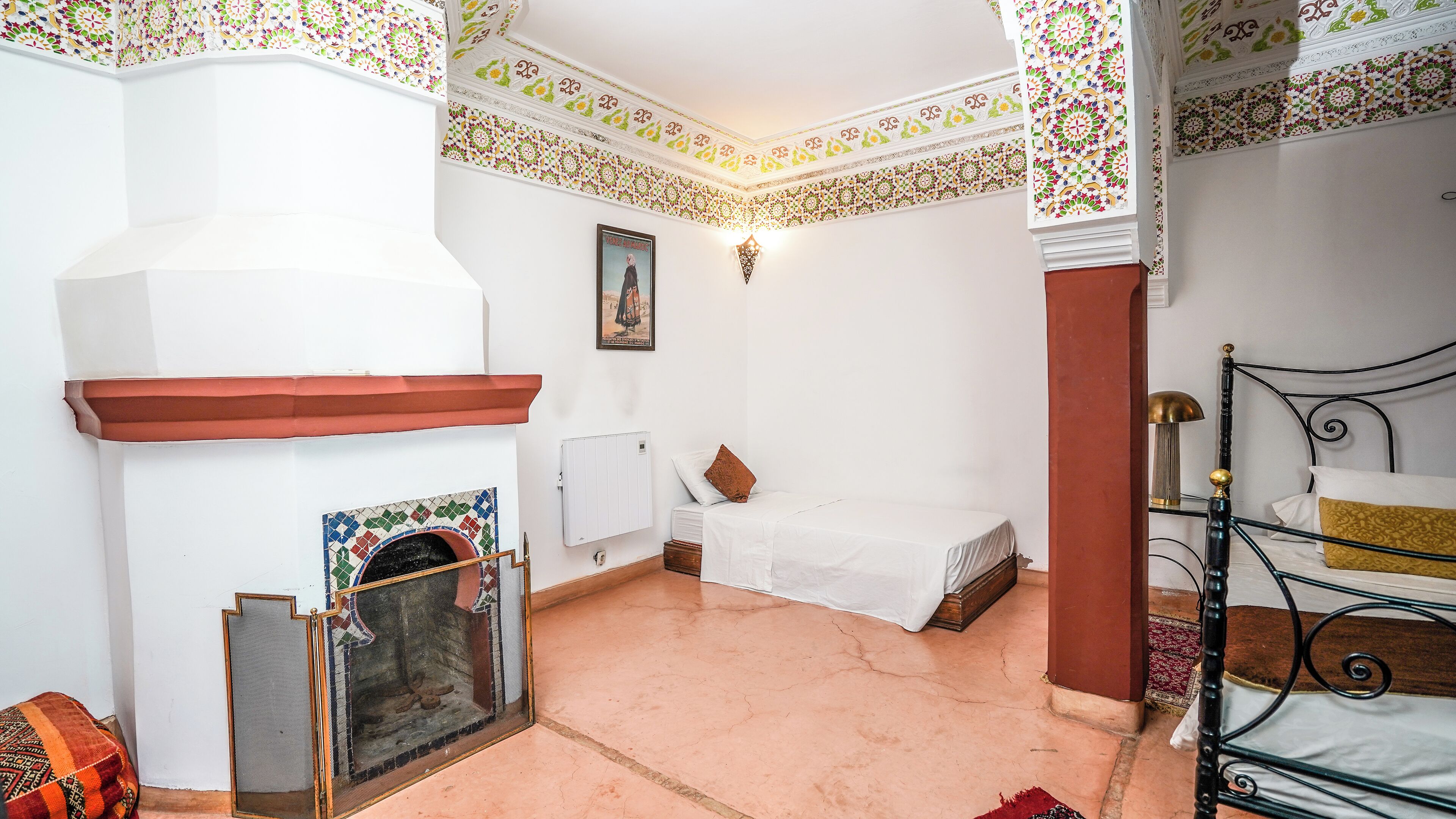 Una habitación con chimenea, una cama, una mesita y una silla.