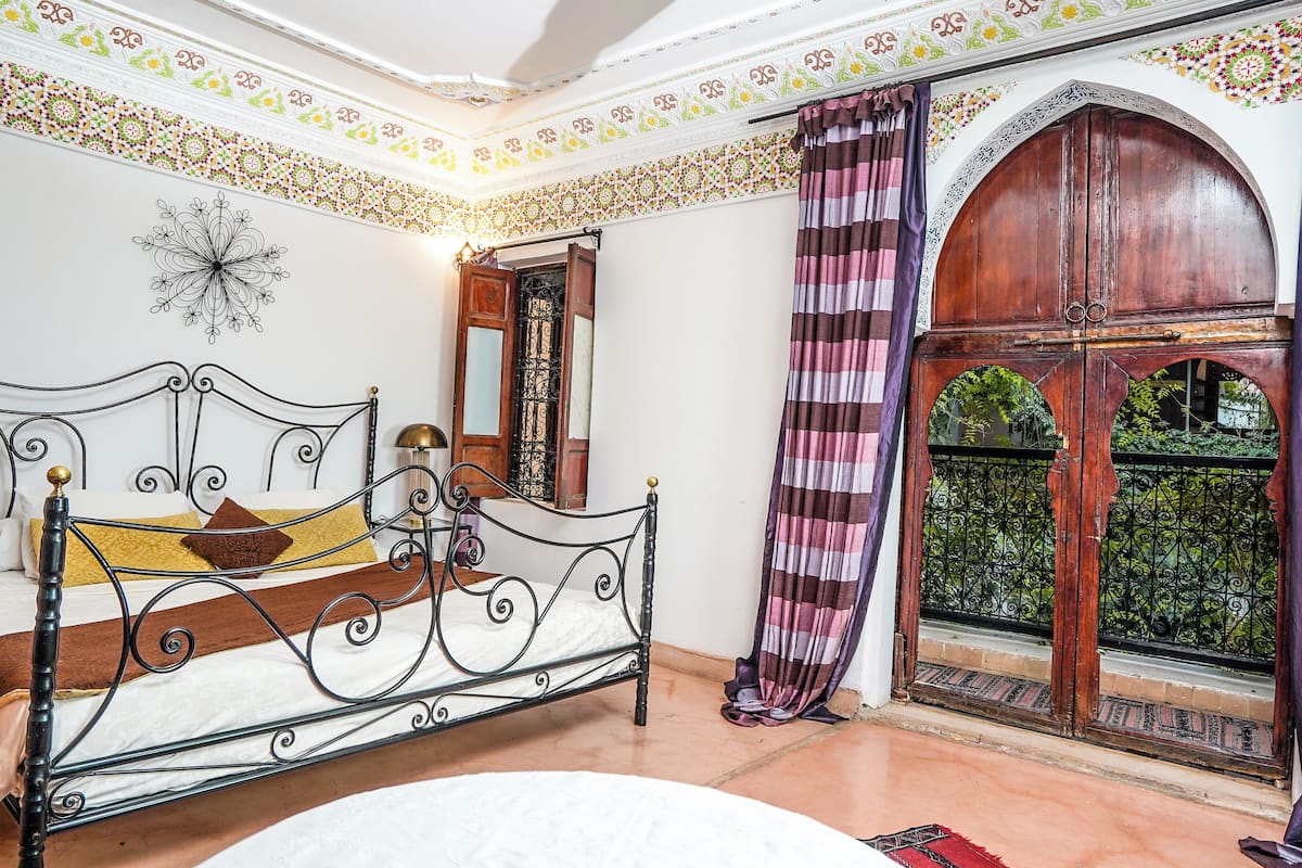 Une chambre de style traditionnel, dotée d’un lit, d’une fenêtre offrant une belle vue et de motifs décoratifs au plafond.