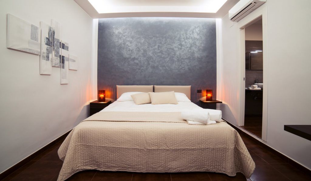 Ein modernes Schlafzimmer mit einem großen Bett, Nachttischen und Kunstwerken an den Wänden.