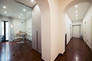 Un amplio pasillo con comedor a la izquierda, que incluye una mesa y sillas.