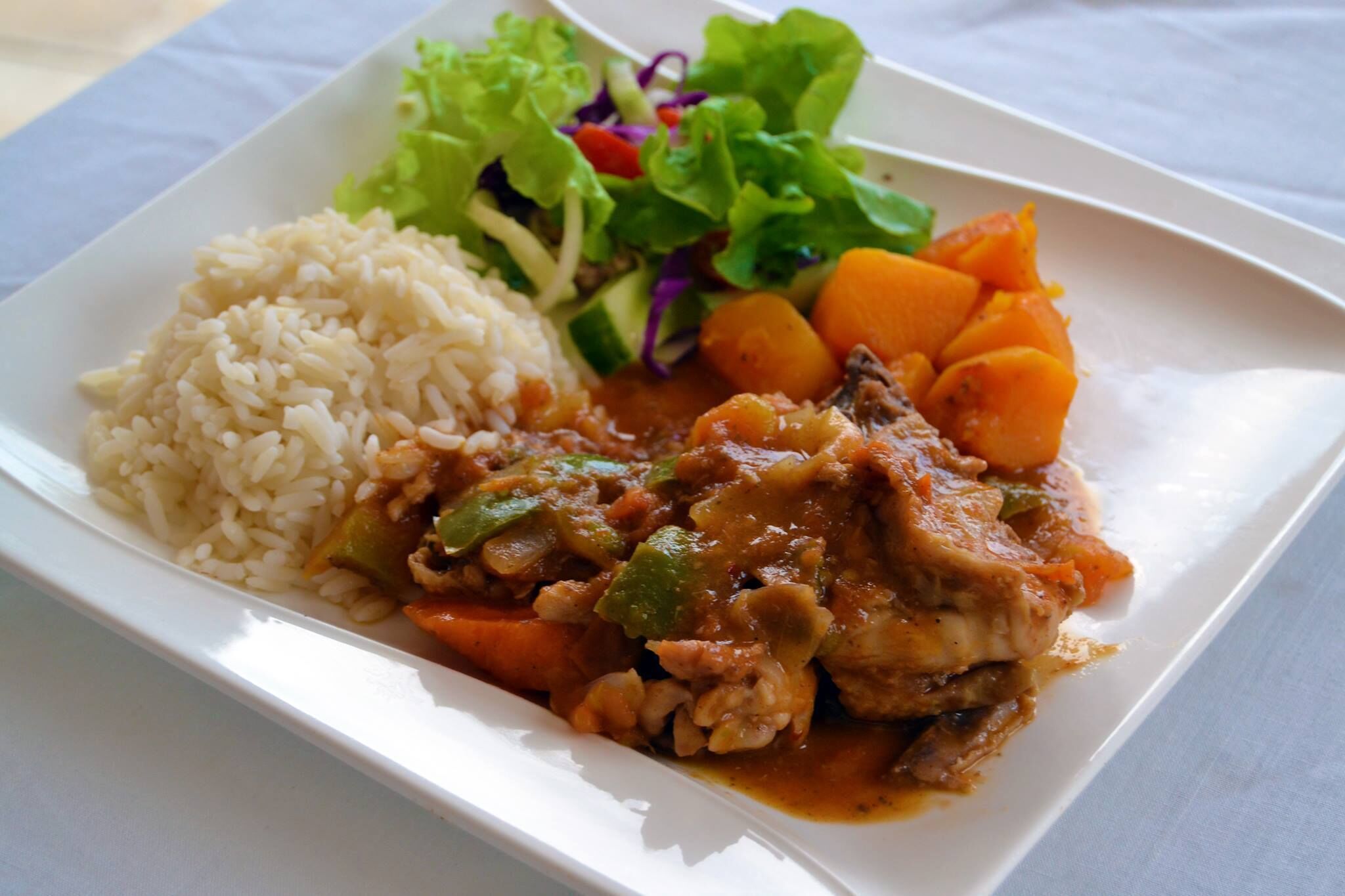 Une assiette de nourriture composée de riz, de légumes et d’un plat de viande.