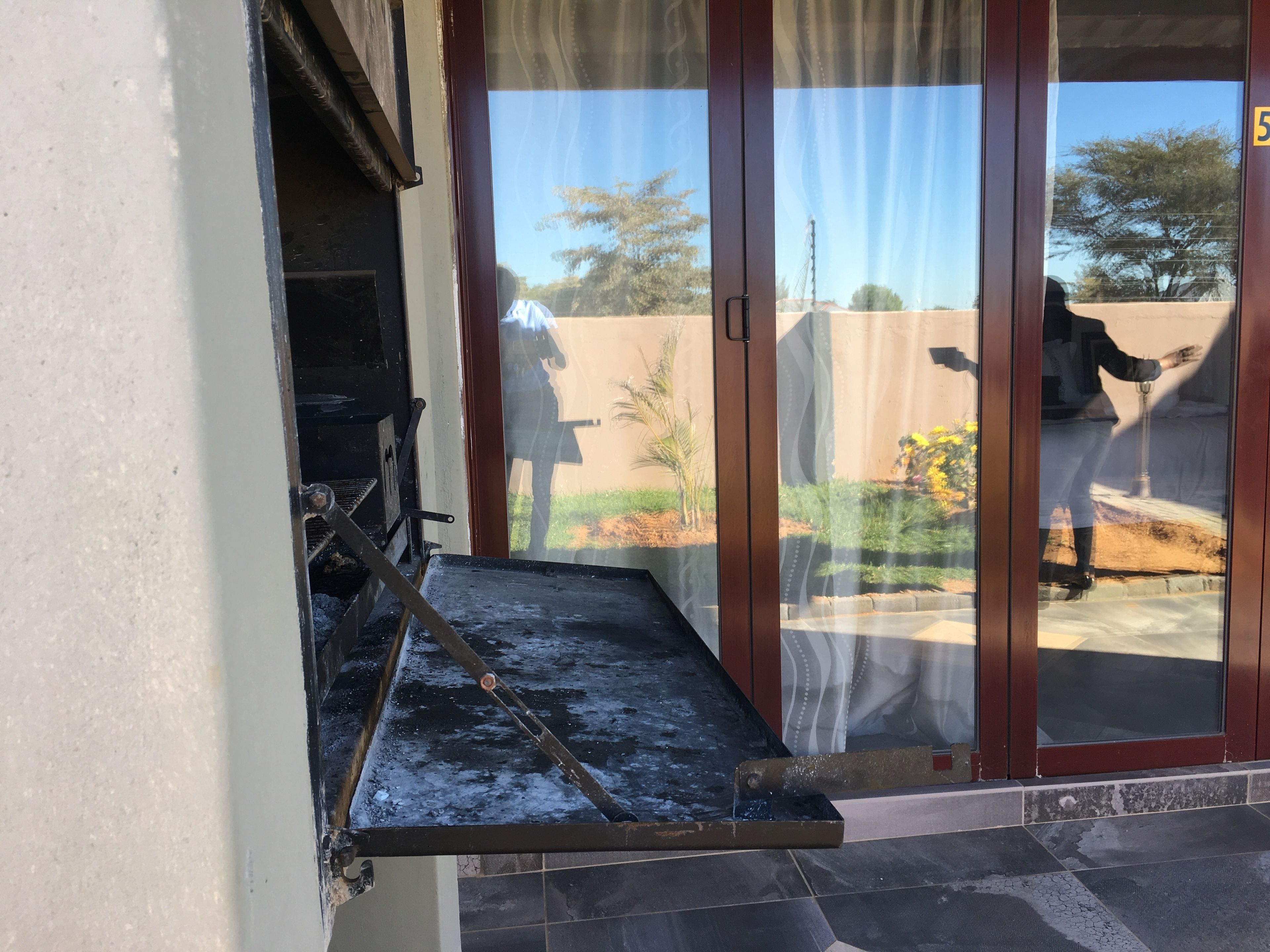 A patio with a grill and a water feature.