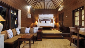 A wooden room with a bed, sofa, and a desk. - Tegal Sari Accomodation (Ubud)