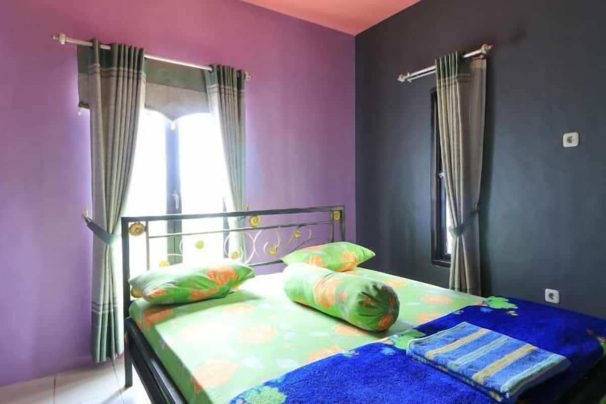 A room with a bed, curtains, and a window.