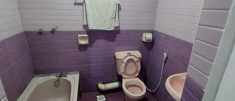 Un baño con bañera, inodoro y lavamanos, todo en una combinación de morado y blanco.