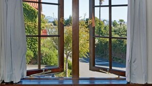 A room with large windows, white curtains, and a view of greenery and buildings outside. - Monaco Resort - Home to Compass Cottage (Monaco)
